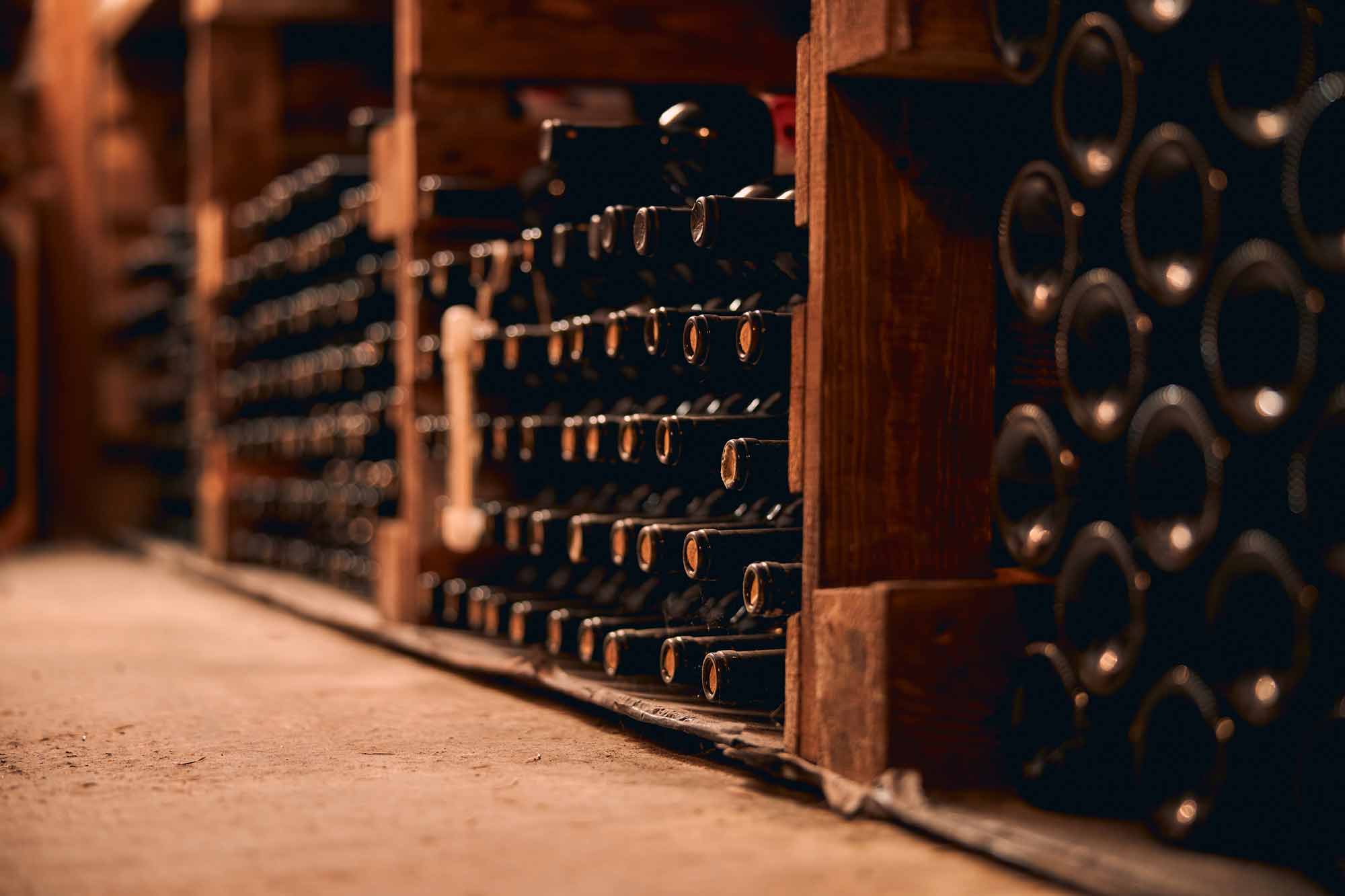 storage-room-with-glass-bottles-alcoholic-drink-wooden-racks-web